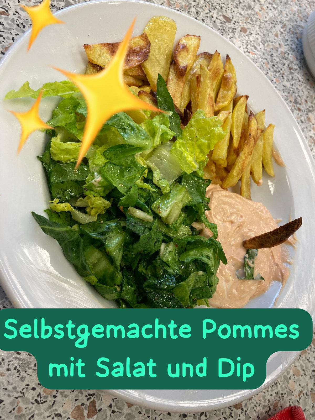 Teller mit selbst gemachten Pommes, grünem Salat und Dip
