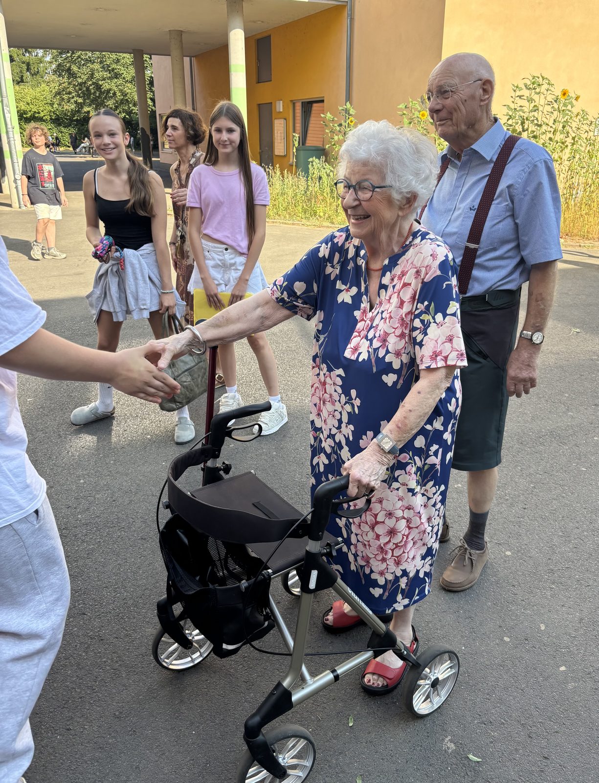 Schülerinnen und Schüler der Klasse 7a begrüßen Frau und Herrn Achten vor dem Schulgebäude.